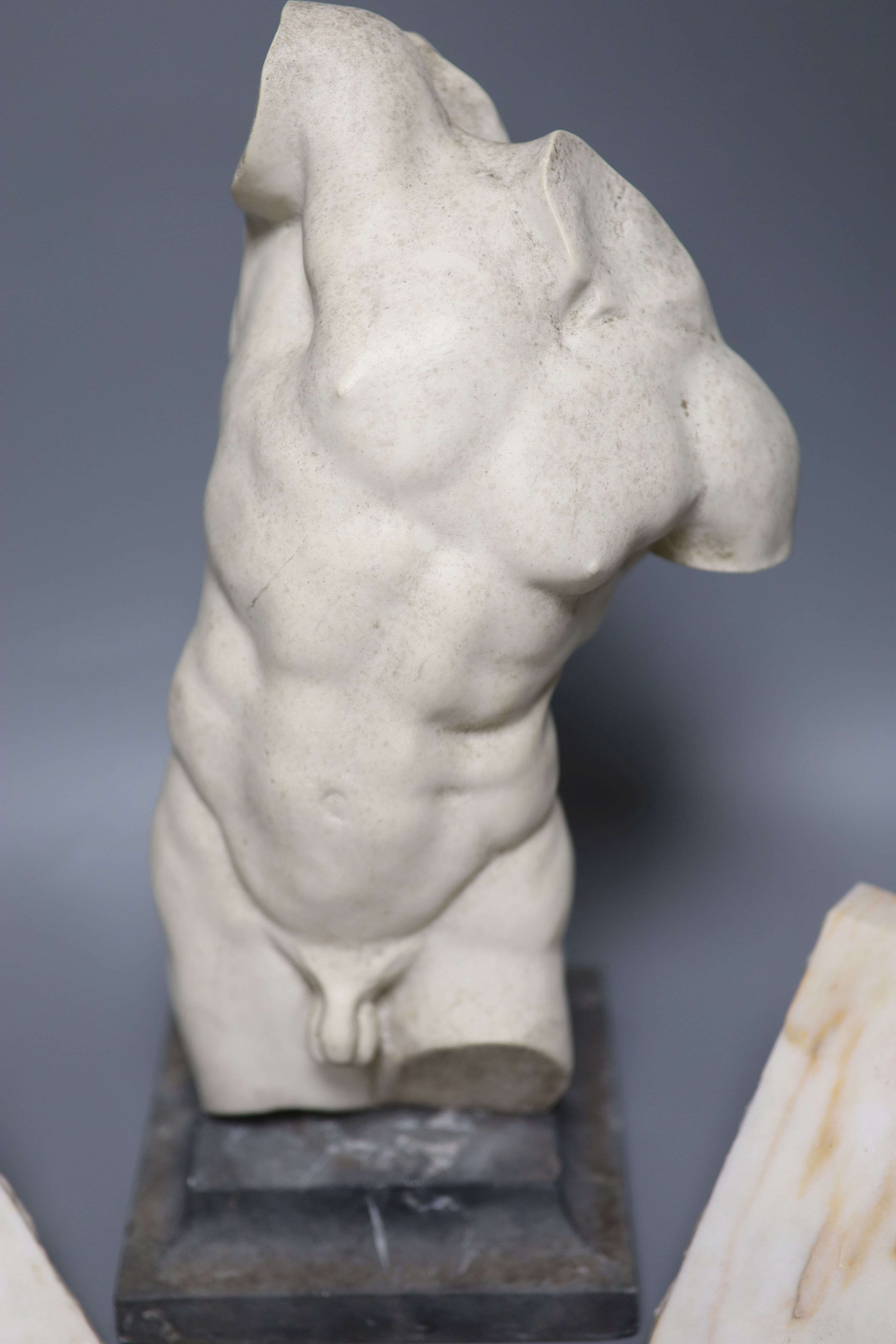A resin bust of a classical torso on stand and a pair of alabaster bookends